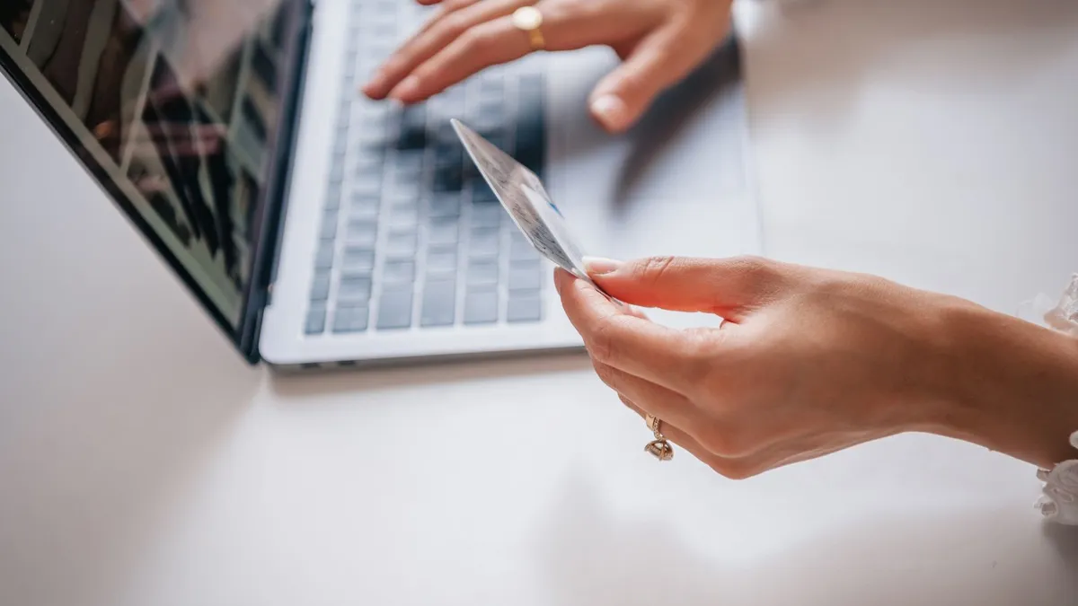 Shopping on Costco.ca with a credit card at a laptop, where the credit cards Costco accepts include Visa