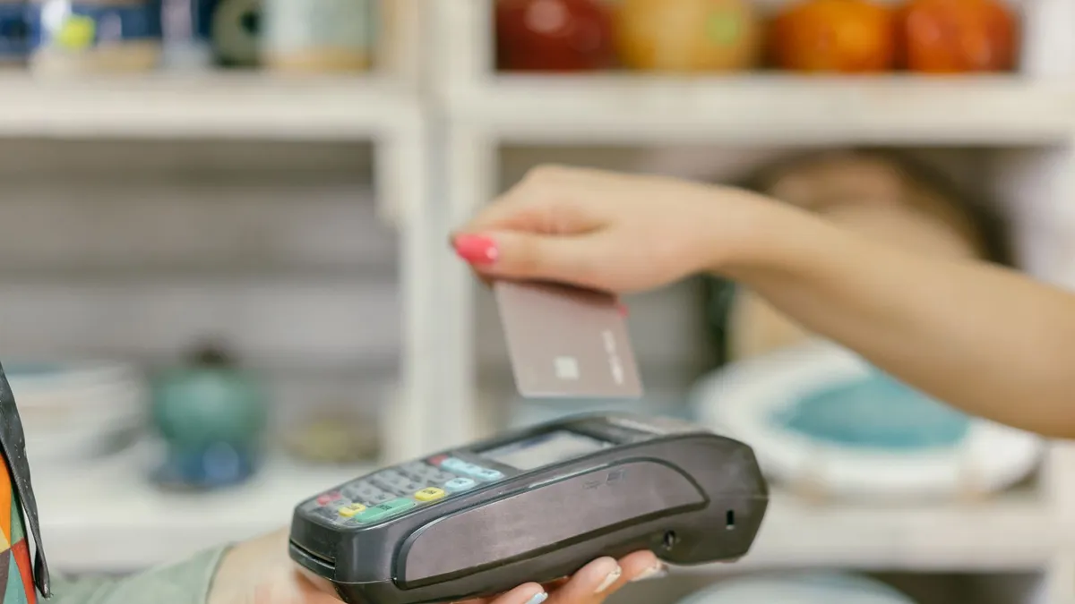 Tapping a Mastercard at a payment terminal, one of the credit cards Costco accepts in Canada
