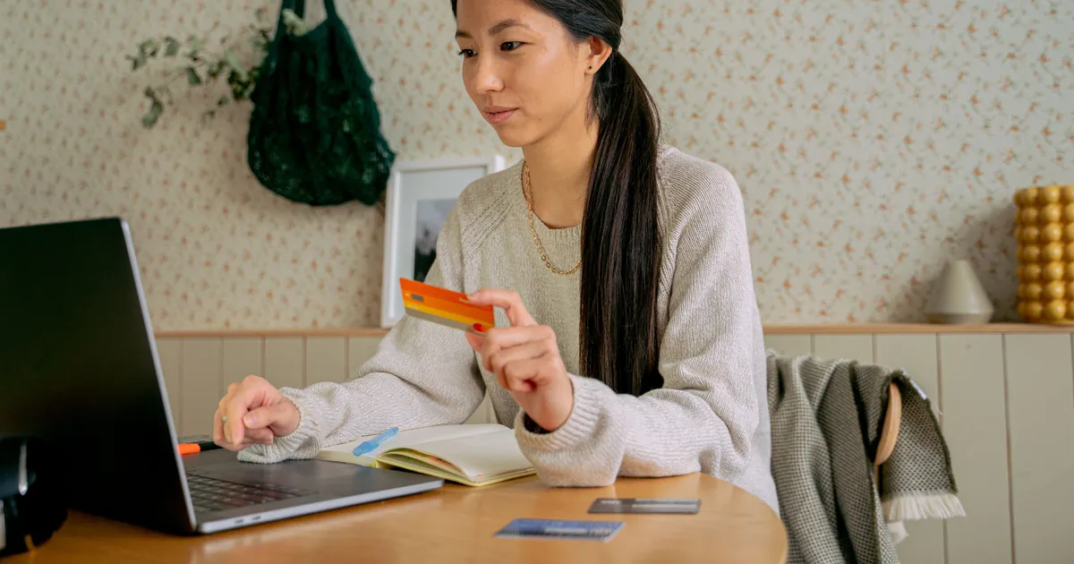 Woman comparing cards at her laptop to choose a credit card in Canada