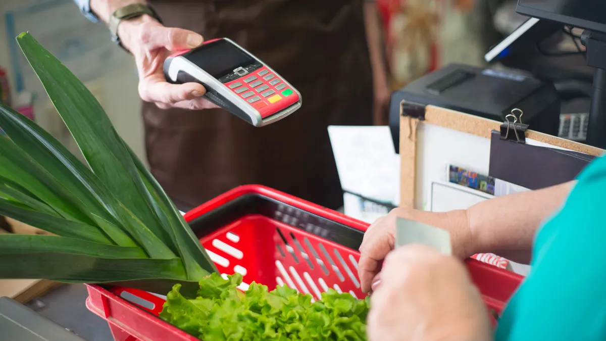 Paying for groceries at a checkout terminal, the biggest line when you choose a credit card